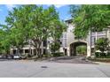 A large condo building with mature trees, and a covered parking area entrance at 650 Campus St # 309, Celebration, FL 34747