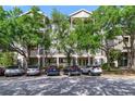 Exterior view of condo building with parking available and mature landscaping at 650 Campus St # 309, Celebration, FL 34747