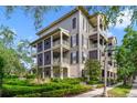Exterior view of a condo building with multiple balconies and beautiful landscaping at 650 Campus St # 309, Celebration, FL 34747