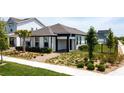 Attractive single-story home with manicured landscaping, featuring a palm tree and inviting walkway at 6514 Barnstorm Way, St Cloud, FL 34771