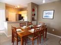 Inviting dining room with a dining table set for six and view to the kitchen at 8809 Dunes Ct # 201, Kissimmee, FL 34747