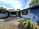 Attractive single story home, showcasing its unique color scheme, landscaped garden, and inviting entryway at 905 W 11Th Ave, Mount Dora, FL 32757