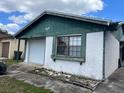 Charming one-story home featuring green trim, a garage, and a well-lit window at 930 Buttercup Dr, Lakeland, FL 33801