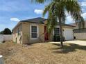 Inviting single-story home with a red front door, attached garage, and low maintenance landscaping at 352 Madina Cir, Davenport, FL 33837