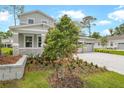 Well manicured front lawn showing stone retaining wall, shrubbery, trees, and part of a charming home at 1067 Cloud Ridge Ct, Mount Dora, FL 32757