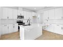 Bright kitchen featuring white cabinets, subway tile backsplash, stainless appliances, and a large center island at 1067 Cloud Ridge Ct, Mount Dora, FL 32757