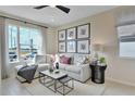 Bright living room with large window, plush sectional, and modern decor, creating a welcoming space at 1067 Cloud Ridge Ct, Mount Dora, FL 32757