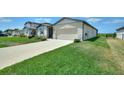 Well-maintained one-story home featuring a two-car garage and a sprawling green lawn at 1158 Oak Valley Dr, Auburndale, FL 33823