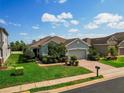Well-maintained home with lush landscaping, a brick driveway, and a two-car garage at 1416 Lexington Ave, Davenport, FL 33837