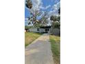 Charming single-story home with a covered front porch, mature landscaping, and a storage shed at 2350 Valley Dr, Apopka, FL 32703