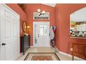 Inviting foyer featuring tile flooring, decorative rug, and an ornate glass front door at 239 King George Dr, Davenport, FL 33837
