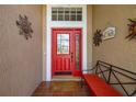 Inviting front entry featuring a red door, tiled porch, and decorative wall art at 239 King George Dr, Davenport, FL 33837