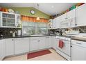 Bright kitchen with white cabinetry, tile backsplash, and modern appliances at 239 King George Dr, Davenport, FL 33837