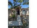 Inviting single-story home with a pathway leading to the front entrance and arched windows at 2451 Quail Run N Blvd, Kissimmee, FL 34744