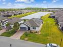 Stunning aerial view of the well-manicured home, pond, and neighborhood at 249 Bella Cortina Dr, Kissimmee, FL 34759