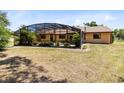 Backyard featuring screened in patio and mature landscaping at 2560 Greenwood Dr, Kissimmee, FL 34744