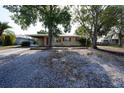 Charming single-story home with mature trees and red shutters for added curb appeal at 26 College Dr, Babson Park, FL 33827