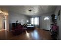 Comfortable living room with lots of natural light, wood floors, and neutral paint at 26 College Dr, Babson Park, FL 33827