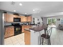 Bright kitchen featuring stainless steel appliances, breakfast bar, and light wood cabinetry at 3071 Seaview Castle Dr, Kissimmee, FL 34746