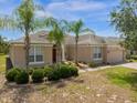 Well-maintained single-story home with mature palm trees and attached two-car garage at 308 Yellow Snapdragon Dr, Davenport, FL 33837