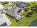 An aerial view of a house with a screened-in pool and solar panels, backing up to a tranquil lake at 3181 Bayview Ln, St Cloud, FL 34772