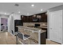 Kitchen featuring a breakfast bar, dark cabinetry, and modern appliances at 341 Gardenia Ct, Kissimmee, FL 34759