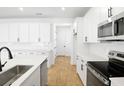 Bright, white kitchen features modern appliances, a large center island, and stylish backsplash at 3765 Deer Ridge Dr, Mount Dora, FL 32757