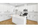 Bright, white kitchen features modern appliances, a large center island, and stylish backsplash at 3765 Deer Ridge Dr, Mount Dora, FL 32757
