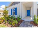 Close up front exterior of home showing blue door, brick walkway, and nicely landscaped front yard at 4928 Worchester Dr, Kissimmee, FL 34746