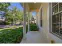 Covered porch area with supporting columns and manicured bushes, creating a serene and inviting entrance at 6821 Cultivation Way, Winter Garden, FL 34787