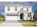 Stunning two-story home features a pristine white exterior and a welcoming blue front door at 9042 Stinger Dr, Davenport, FL 33896