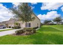 A manicured lawn and tidy landscaping surround this home with an attached garage at 9056 Wildflower Ln, Kissimmee, FL 34747