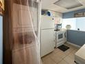 Efficient kitchen with modern appliances, white cabinetry, and a stacked washer and dryer unit at 914 Caribbean Dr, Davenport, FL 33897