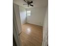 Clean bedroom features modern wood flooring, and natural light from a window at 924 Ferndell Rd, Orlando, FL 32808