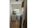 Functional laundry room with modern washer, dryer, water heater, and a window at 924 Ferndell Rd, Orlando, FL 32808