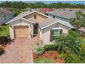 A charming single-Gathering home featuring lush landscaping, brick driveway and covered entry at 105 Palazzo Ln, Kissimmee, FL 34759