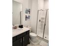 Modern bathroom with vanity, shower and decorative art at 1058 Splash Shot Pl, Davenport, FL 33896
