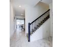 Bright hallway with tile flooring, a staircase, and access to dining area at 1058 Splash Shot Pl, Davenport, FL 33896