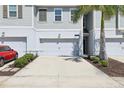 Inviting exterior view of a townhome featuring an attached garage and manicured landscaping at 12379 Turtle Grass Dr, Orlando, FL 32824