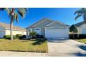 Inviting single-story home featuring an attached two-car garage and lush, green lawn at 16732 Glenbrook Blvd, Clermont, FL 34714