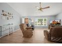 Cozy living room with wood floors, a ceiling fan, and a bright bay window at 1700 E Clinton Dr, St Cloud, FL 34769