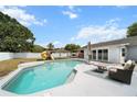 Inviting backyard pool with a lounging area, a playset and well-maintained grass at 1700 E Clinton Dr, St Cloud, FL 34769