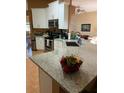 Modern kitchen featuring white cabinets, stainless steel appliances, granite counters, and an eat-in island at 1920 Triumfo Cir, Kissimmee, FL 34744