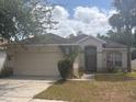 Charming single-story home features a two-car garage, palm tree and a well-maintained lawn at 1948 Bridgeview Cir, Orlando, FL 32824