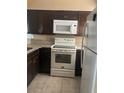The kitchen features dark cabinets, granite countertops, and modern white appliances at 228 Scottsdale Sq # 228, Winter Park, FL 32792