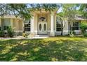 Elegant entrance featuring double doors, columns, transom window, and arched windows at 2374 Eagle Trace Dr, Kissimmee, FL 34746