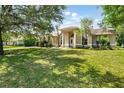 Inviting single-story home with a large lawn, mature landscaping, and architectural entrance at 2374 Eagle Trace Dr, Kissimmee, FL 34746
