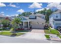 Charming two-story home with a well-maintained lawn, a driveway, and beautiful landscaping at 2487 Empress Dr, Kissimmee, FL 34741