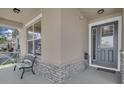 Inviting front porch with stone accents, a decorative front door, and a comfortable bench at 2487 Empress Dr, Kissimmee, FL 34741