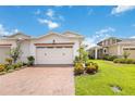 Charming villa featuring a red brick driveway and lush landscaping at 2503 Yellow Brick Rd, St Cloud, FL 34772